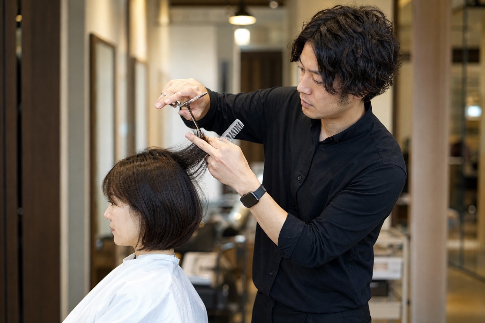 ヘアサロンでカウンセリングを行うスタイリスト