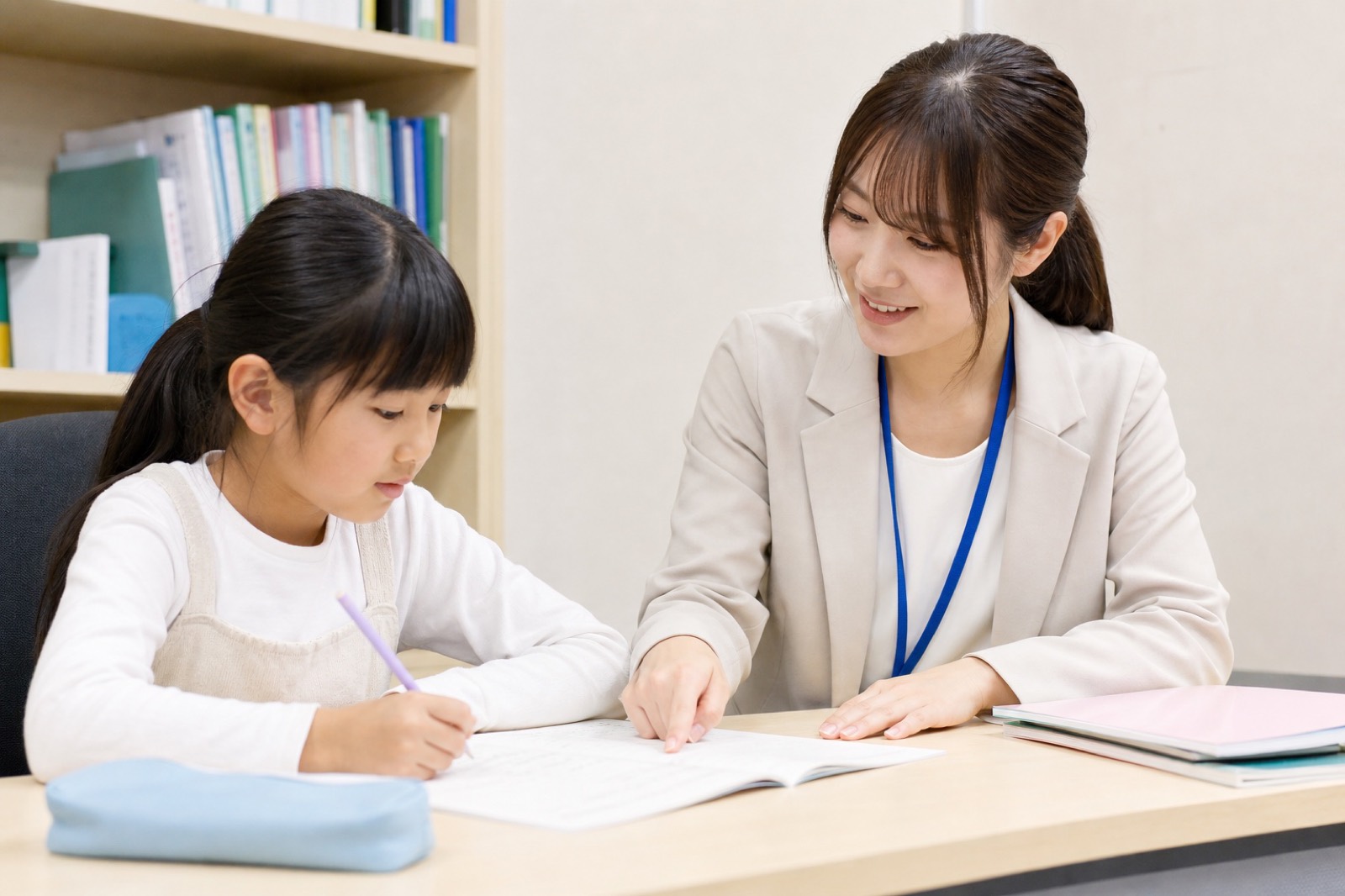 算数の問題をノートに書きながら指導する場面